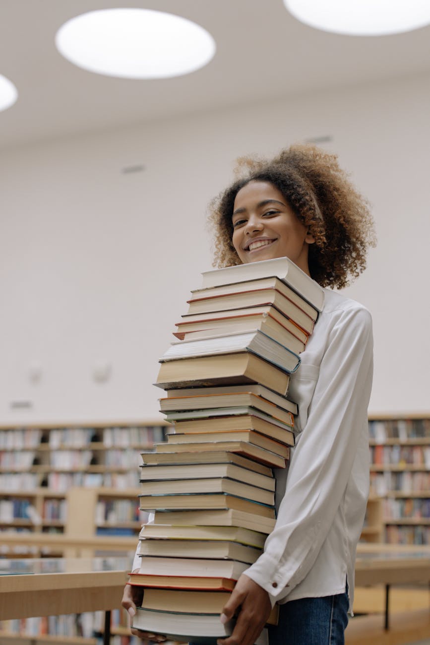 photo of woman carrying bundle of books