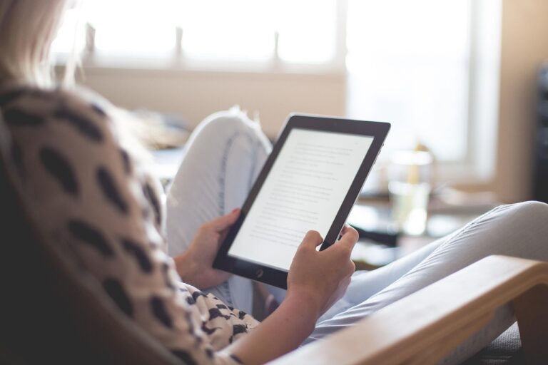 Femme lisant un livre sur tablette Kindle